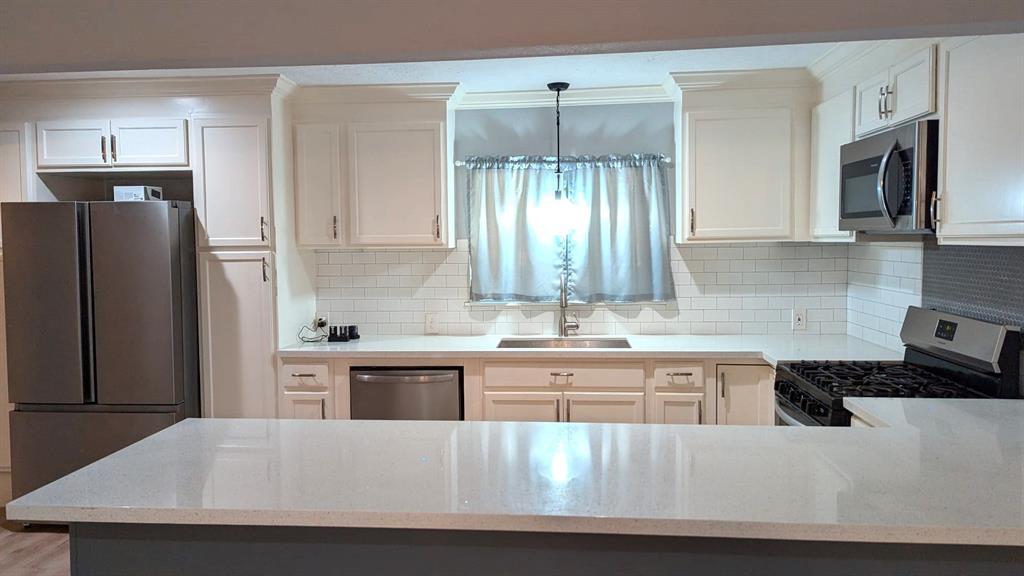 a kitchen with kitchen island a sink appliances and cabinets