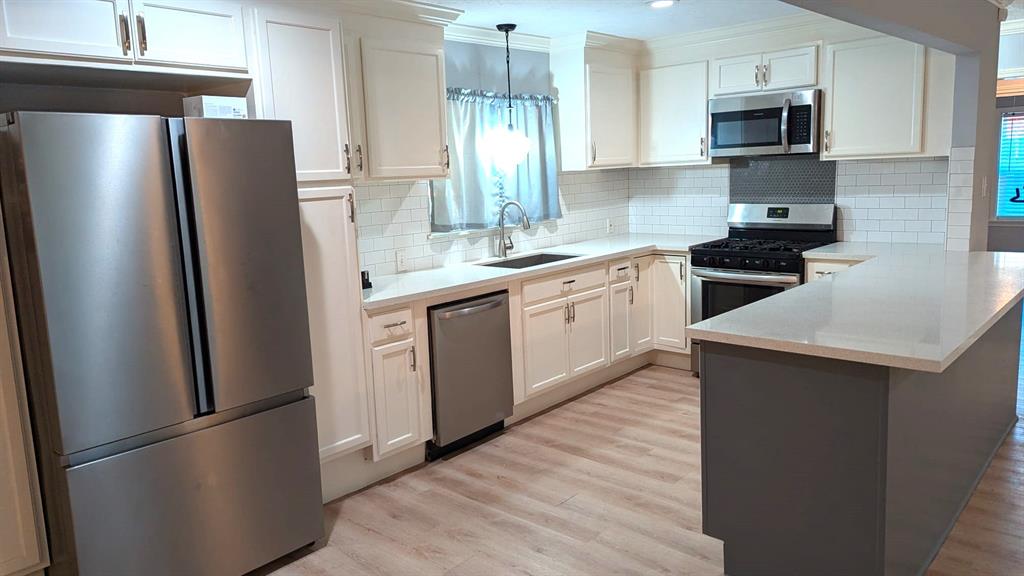 a kitchen with stainless steel appliances refrigerator and microwave