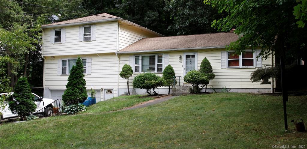 a view of a house with a yard and sitting area