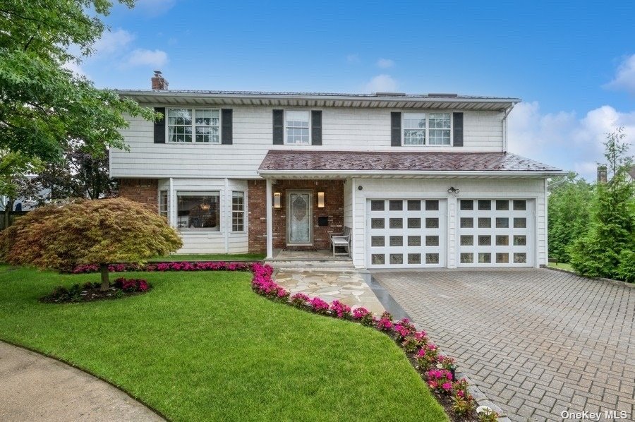 a front view of a house with a garden and yard