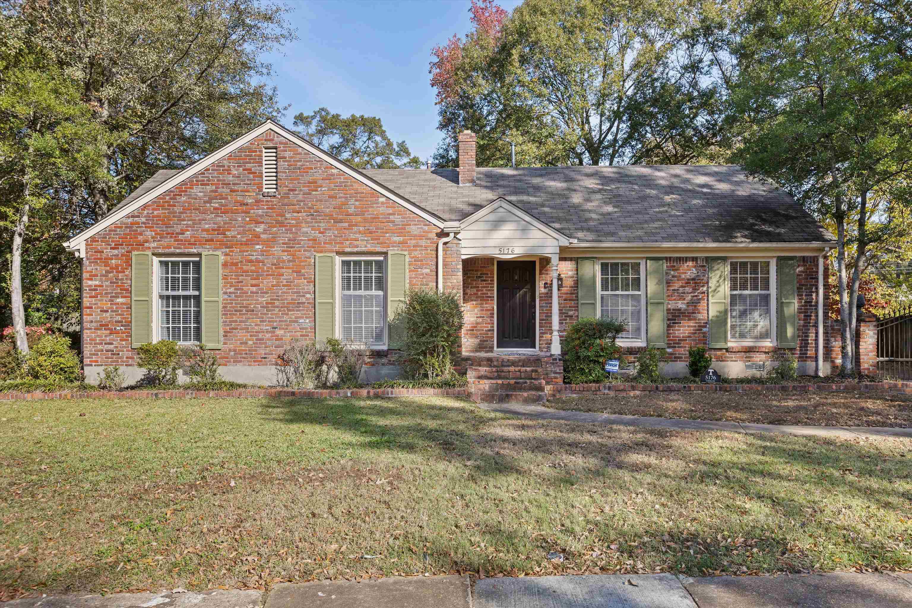 a front view of a house with a yard and chairs