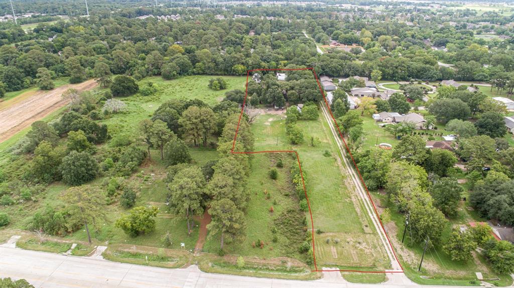 an aerial view of residential houses with outdoor space and trees