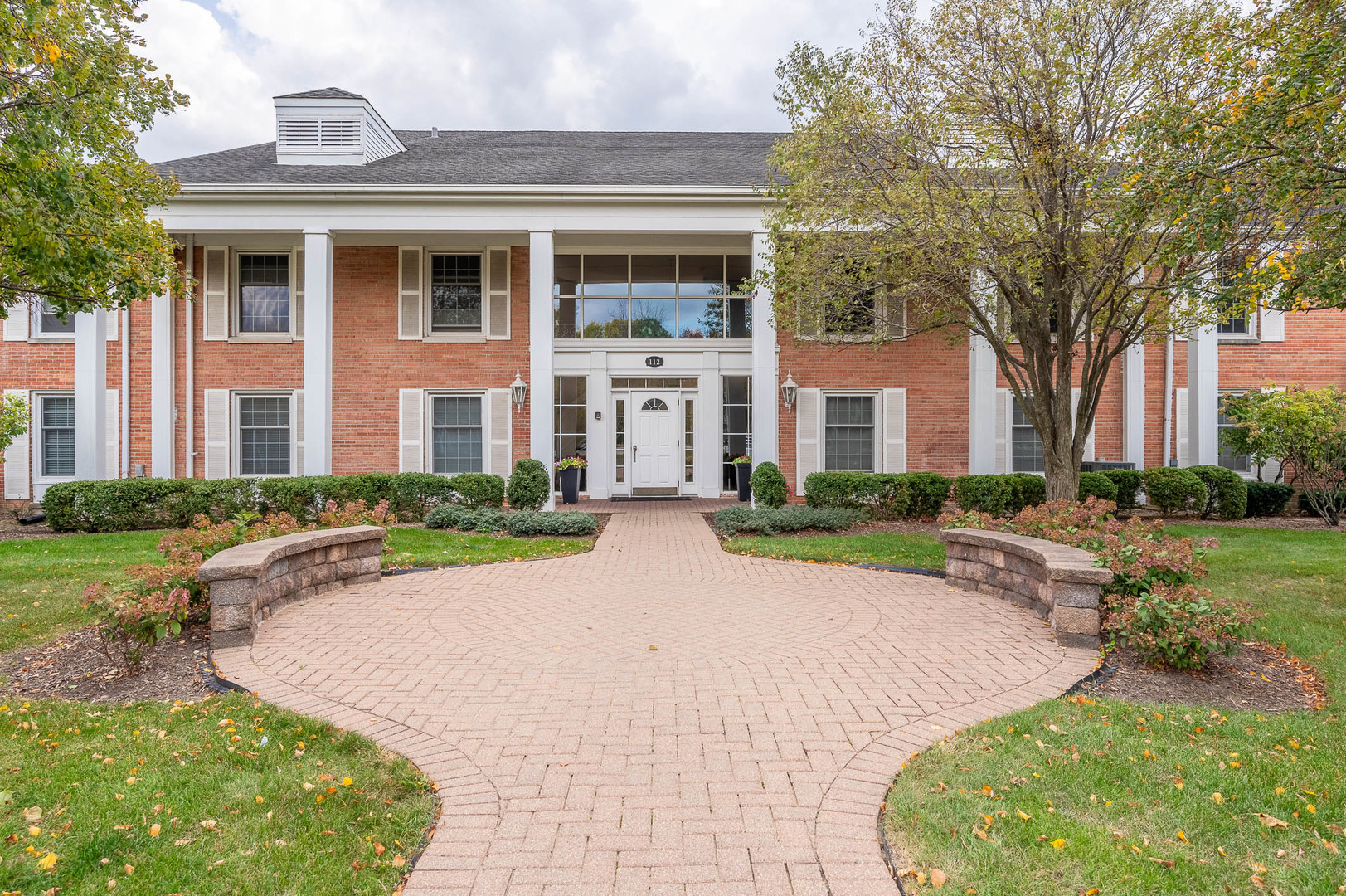 a front view of a house with yard and green space