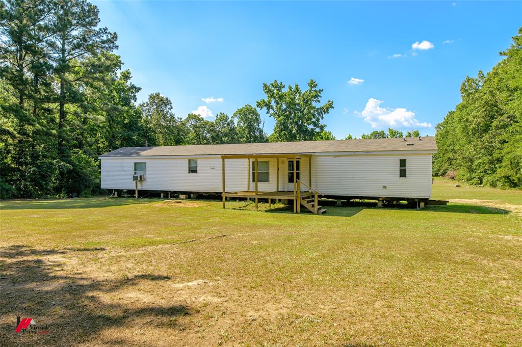 a front view of house with yard and trees in the background