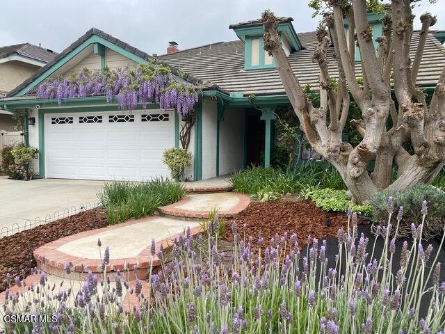 a view of a wooden house with a small yard and plants