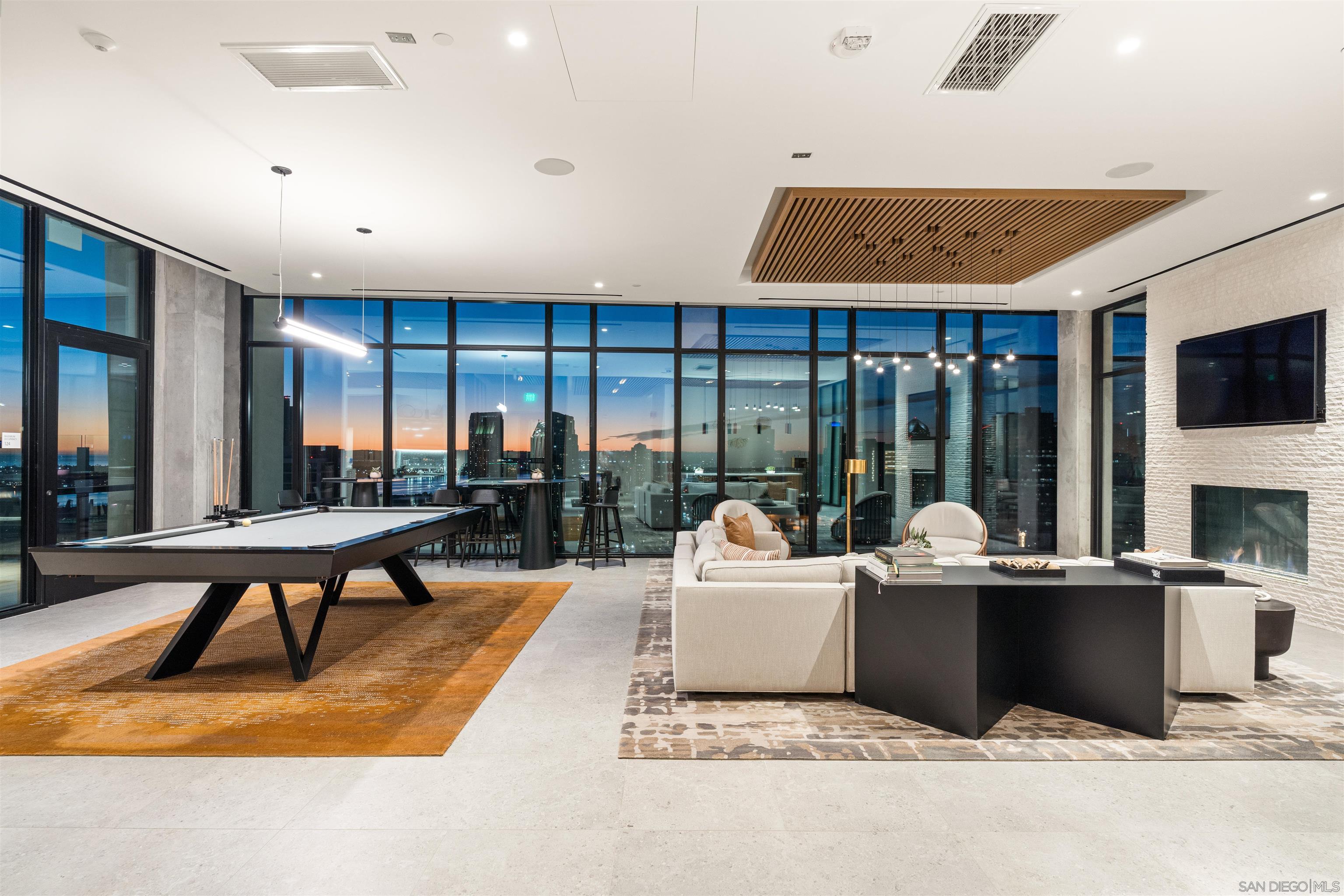 a living room with furniture a flat screen tv and floor to ceiling window