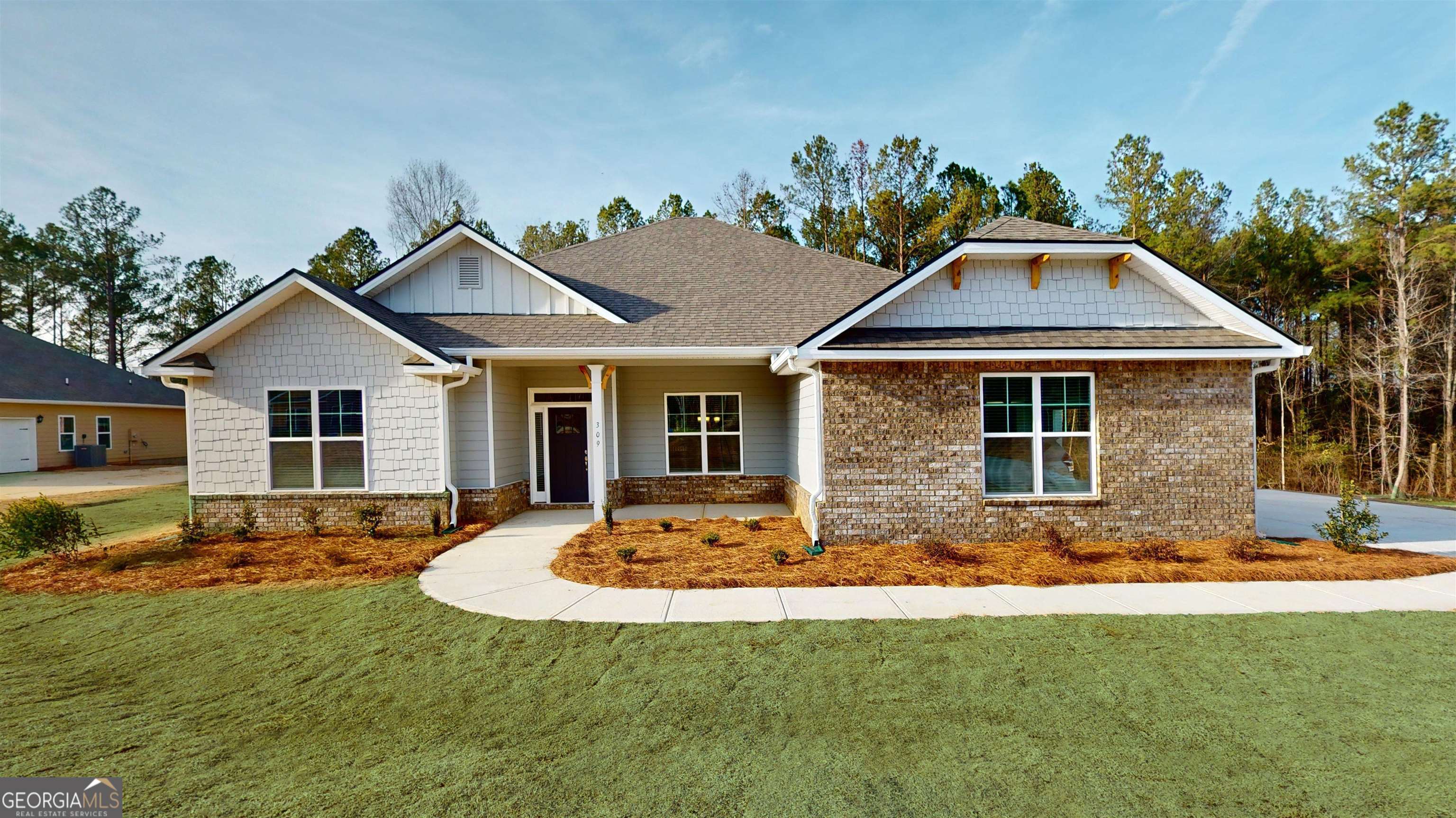 a front view of a house with a yard outdoor seating and garage