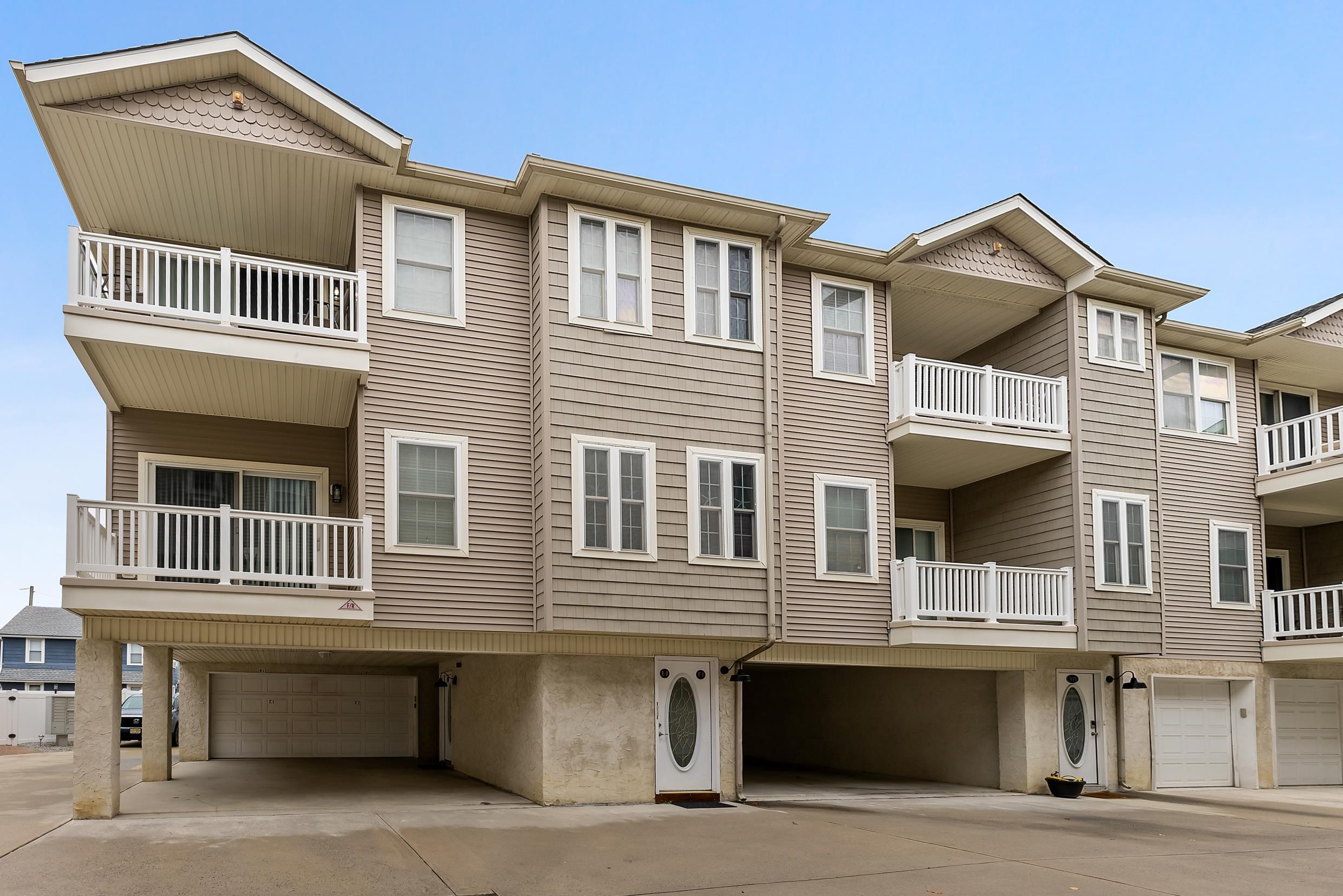 a front view of residential houses with parking