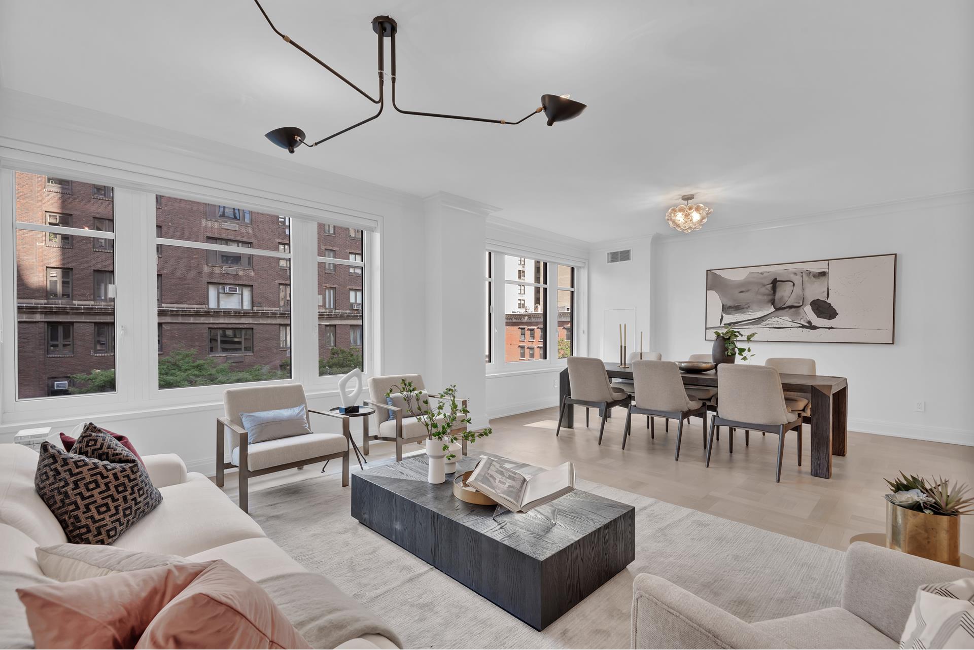 a living room with furniture potted plant and kitchen view