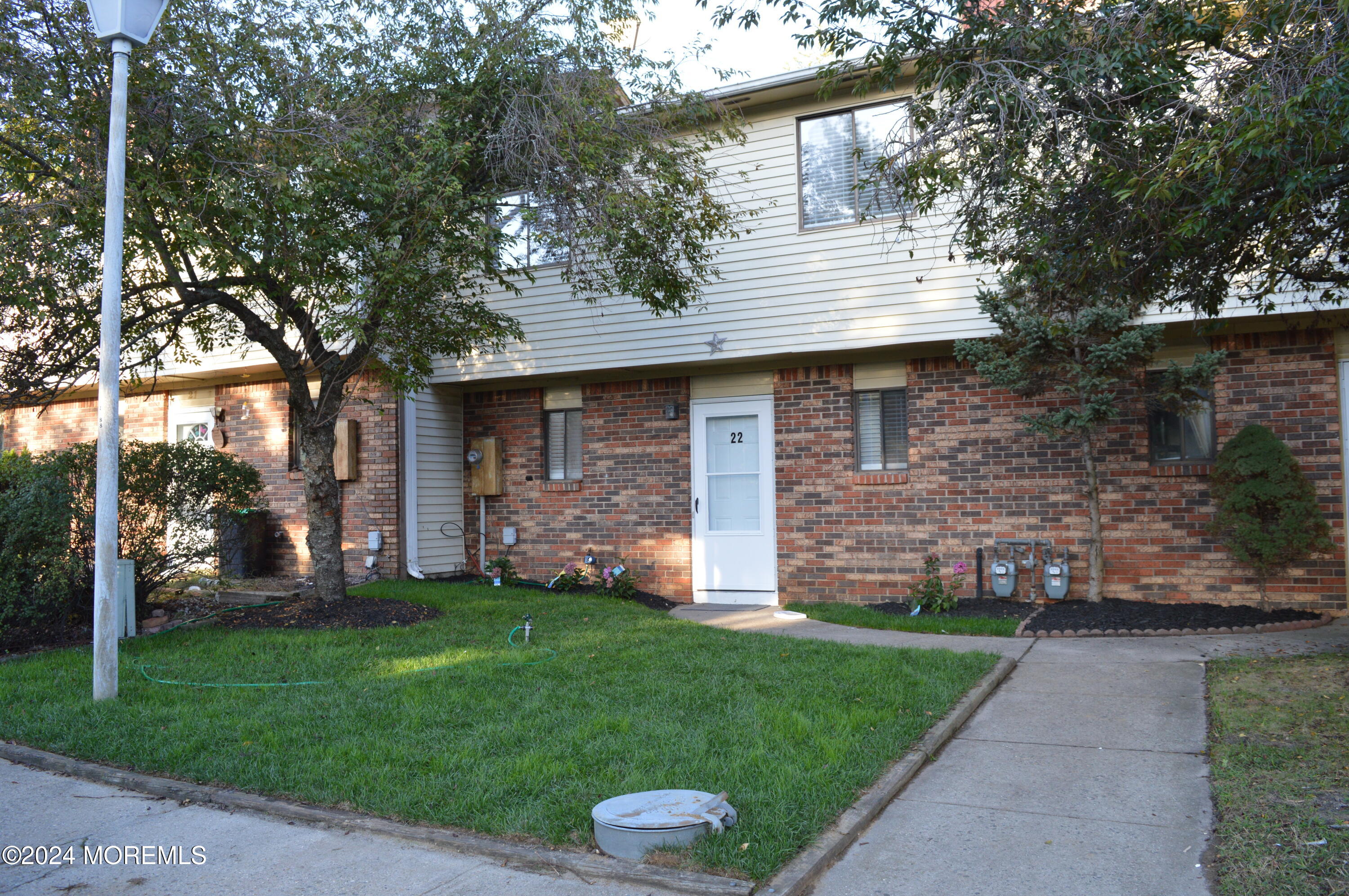 a view of a house with a yard porch and a tree