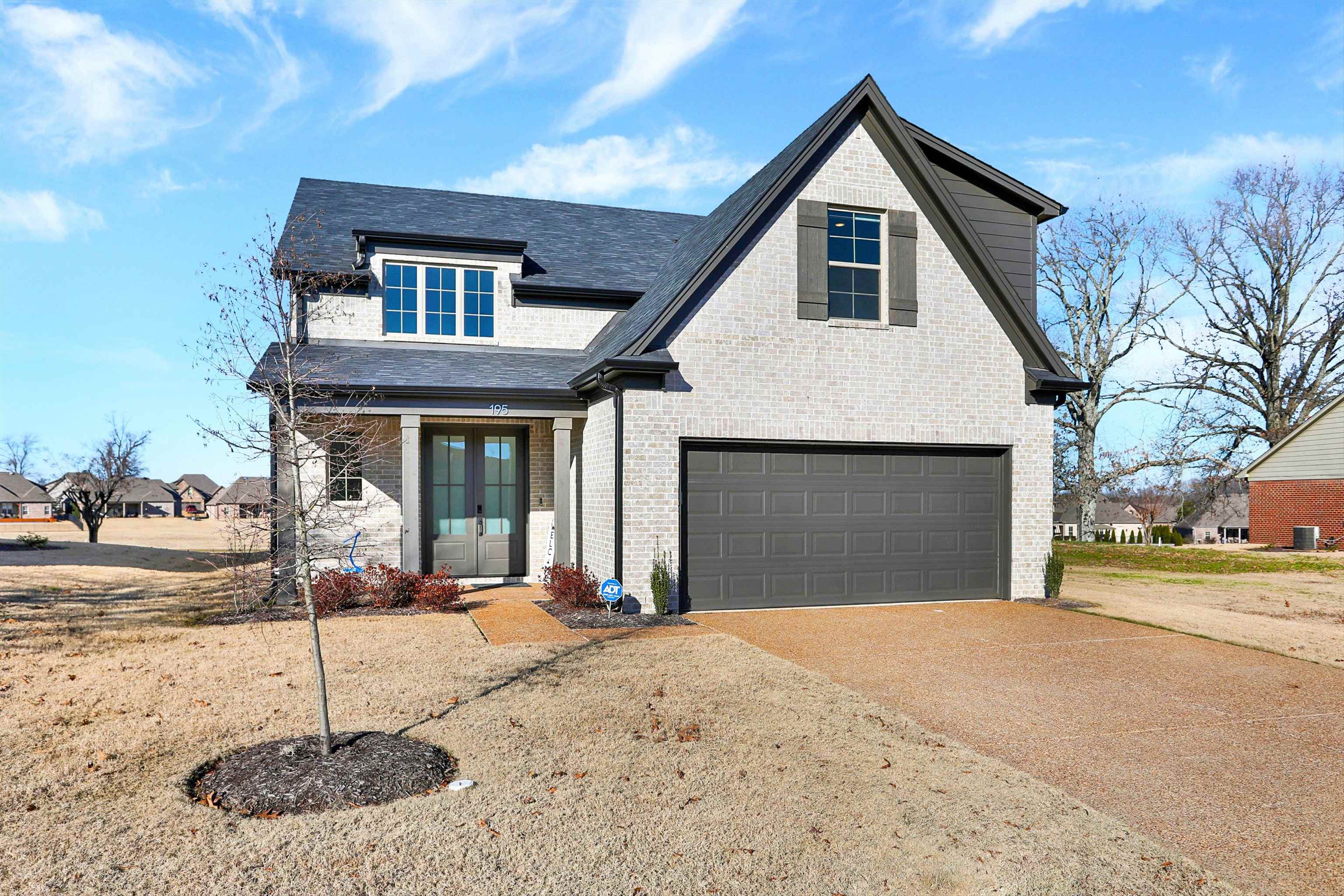 a front view of a house with a yard and garage