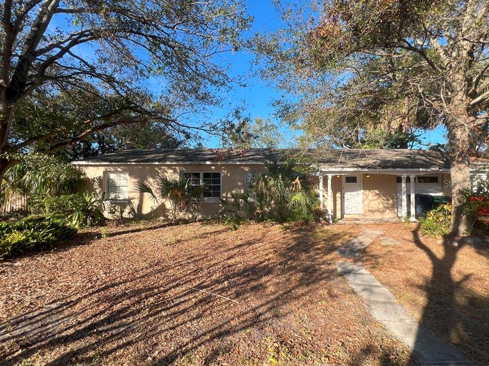 a front view of house with yard and trees around