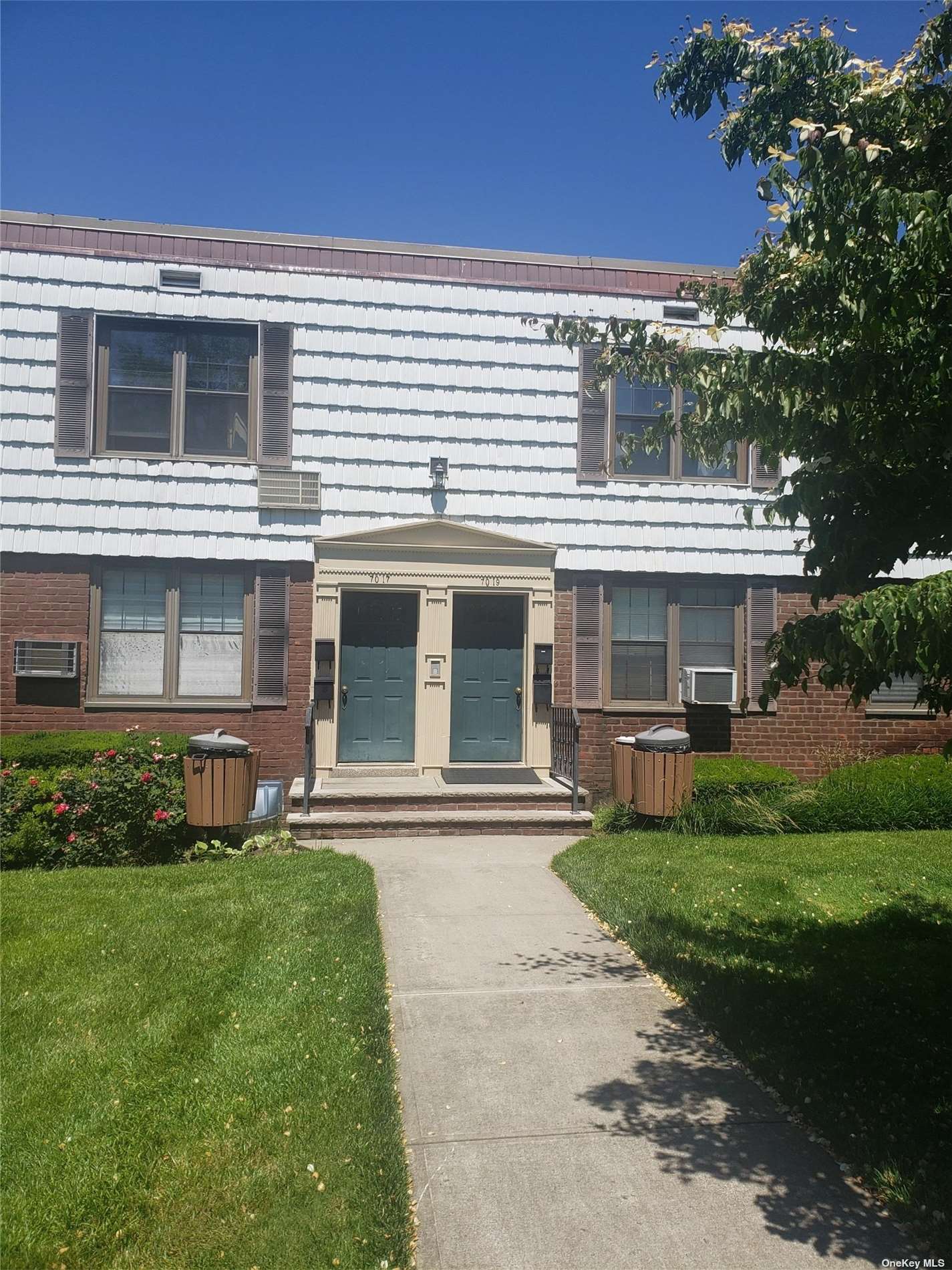 a front view of a house with a garden and yard