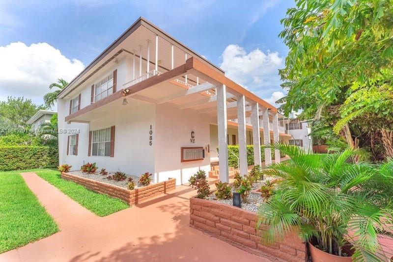 a view of a house with backyard and sitting area