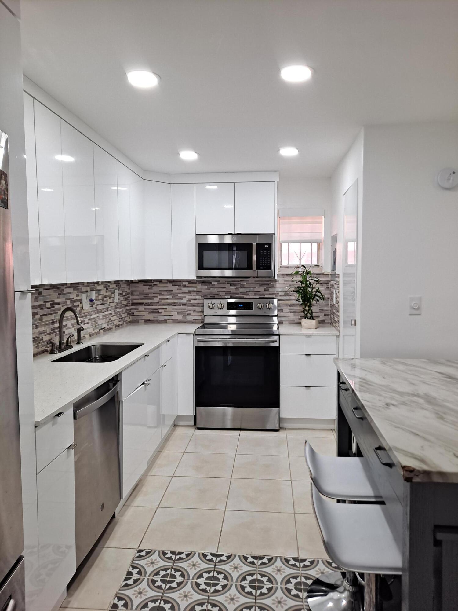 a kitchen with granite countertop a stove sink and cabinets