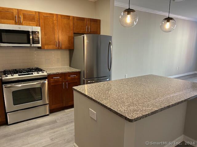 a kitchen with granite countertop a stove and a microwave