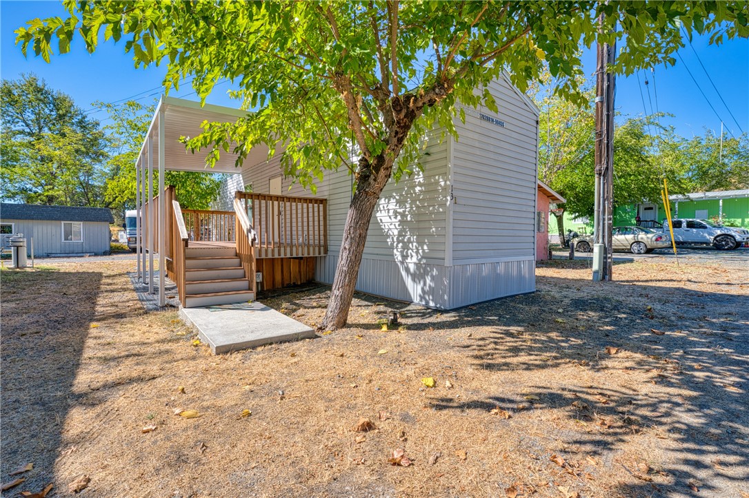 a view of backyard with wooden fence and a large tree