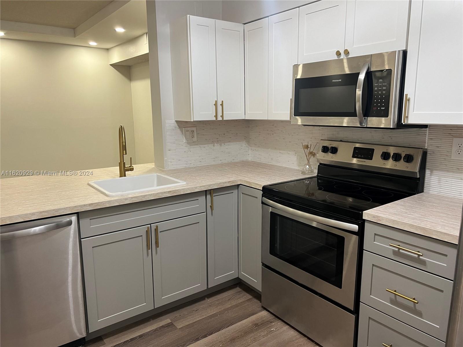 a kitchen with stainless steel appliances a stove a microwave and cabinets