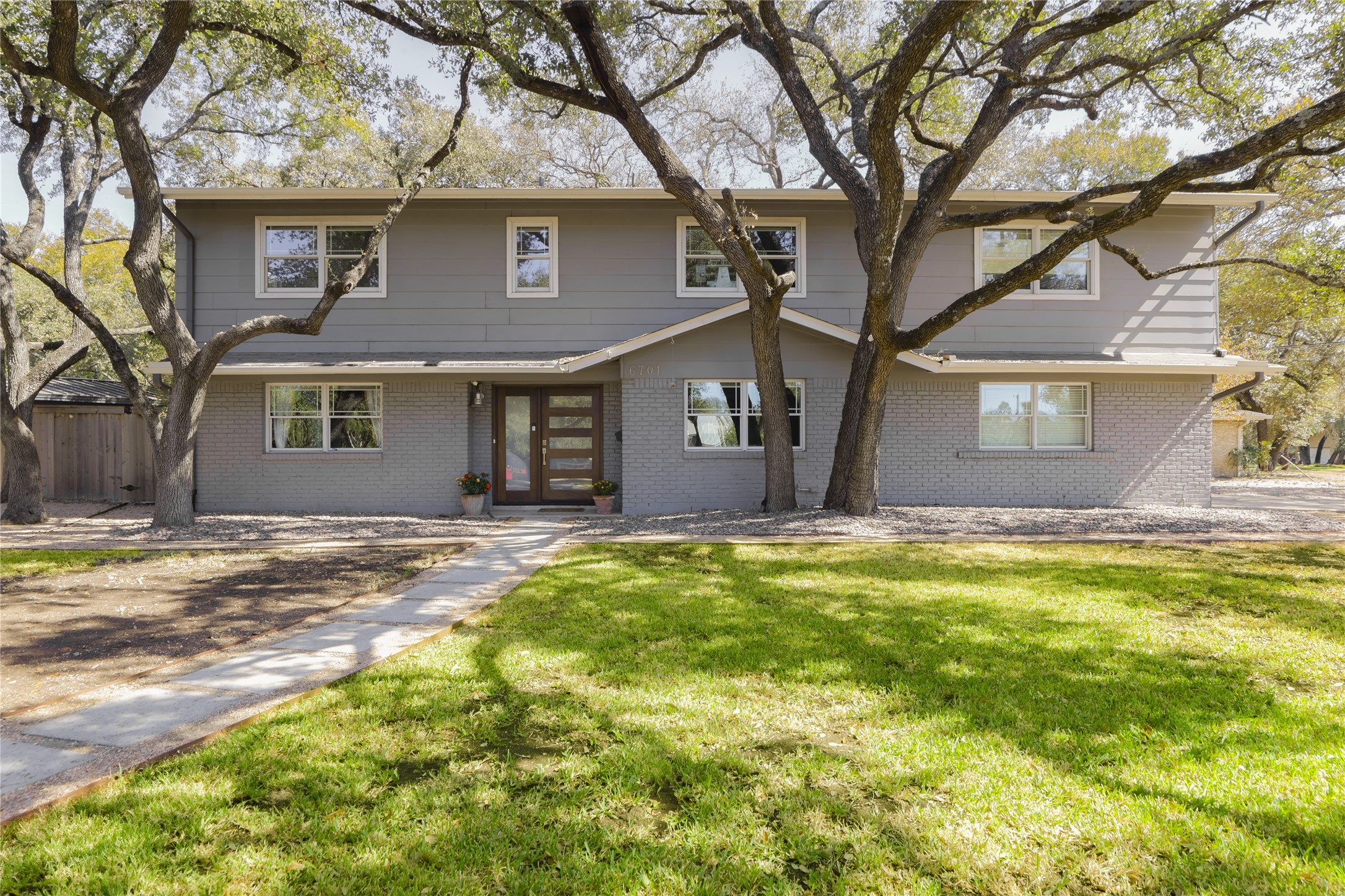 a view of a house with a yard and large tree