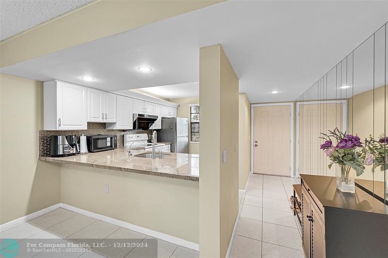 a kitchen with stainless steel appliances kitchen island granite countertop a sink and cabinets