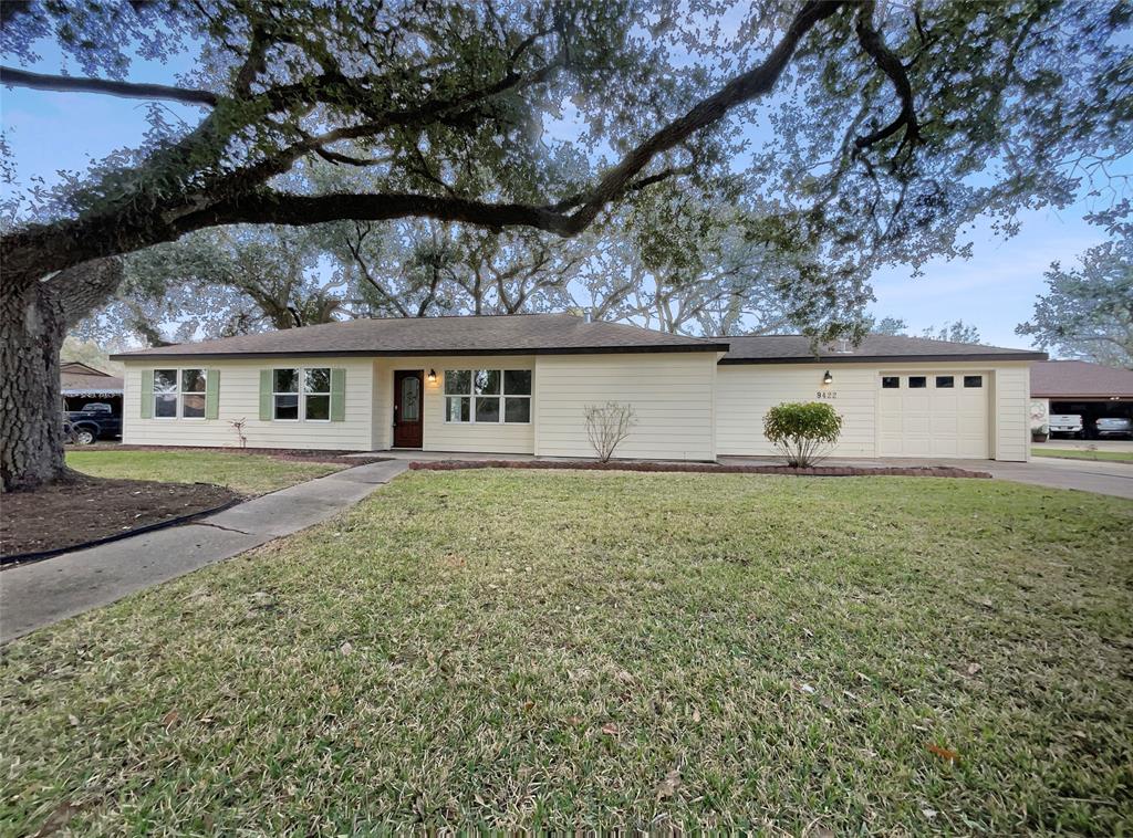 a front view of house with yard and trees around