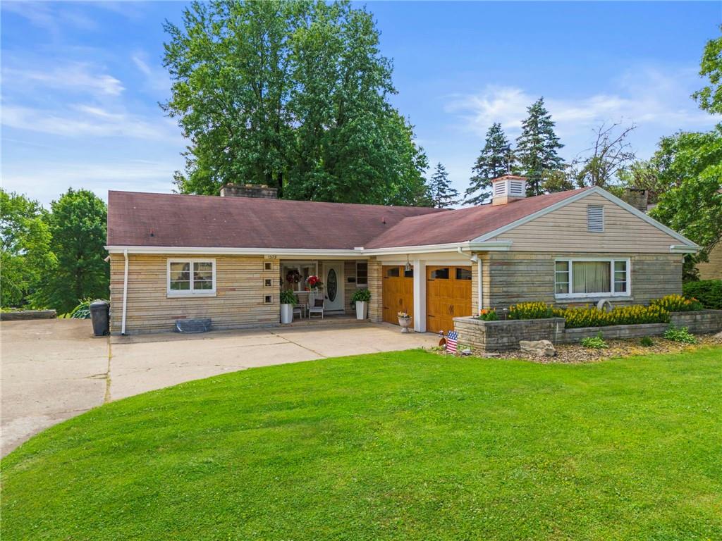 a front view of a house with a yard and green space