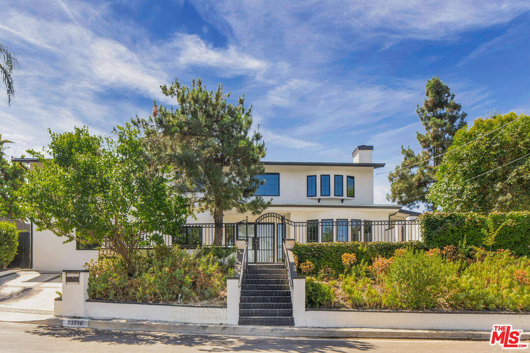 a front view of a house with a garden