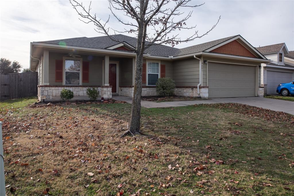 a view of a house with a yard and large tree