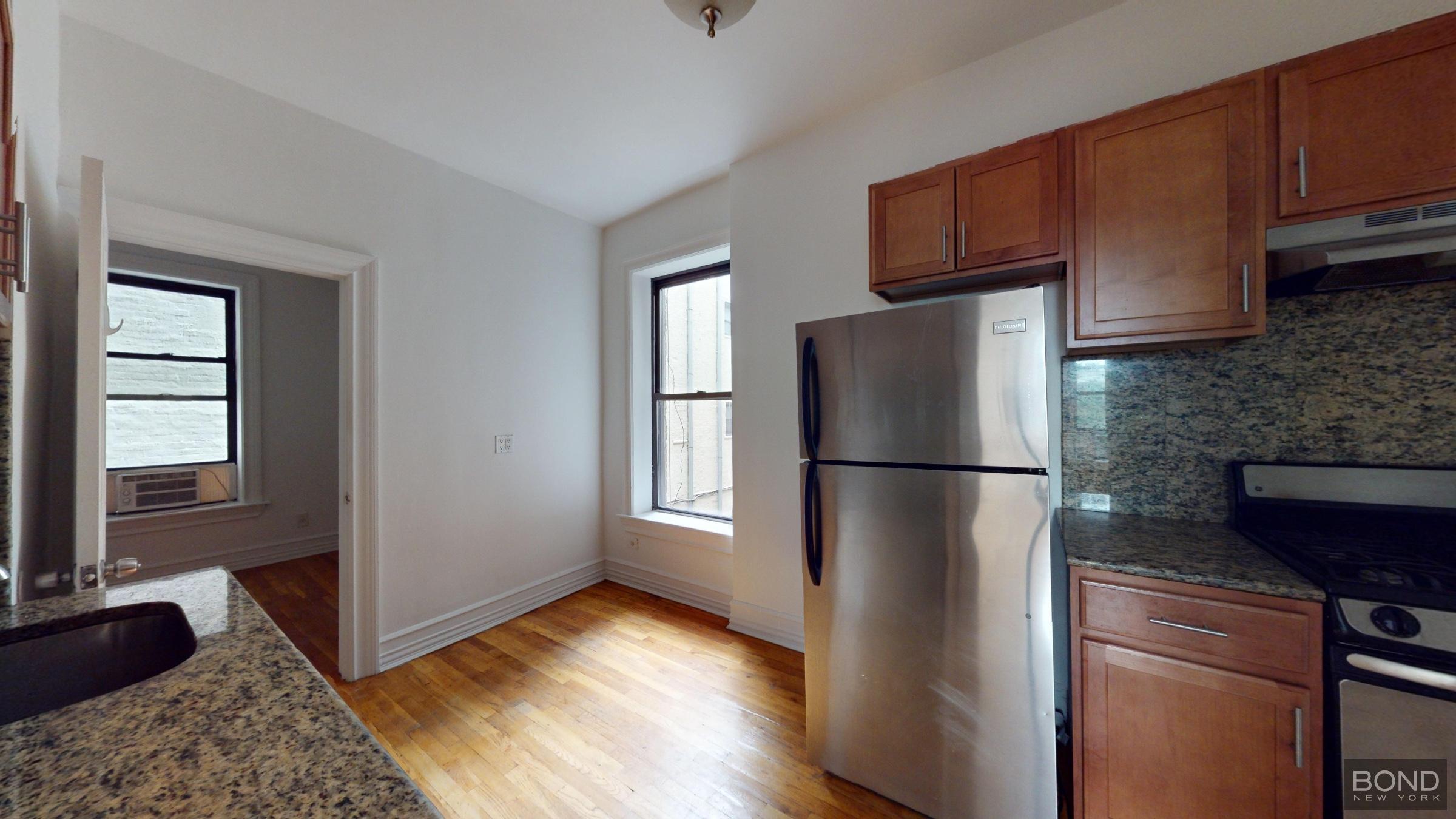 a kitchen with a refrigerator cabinet and a microwave