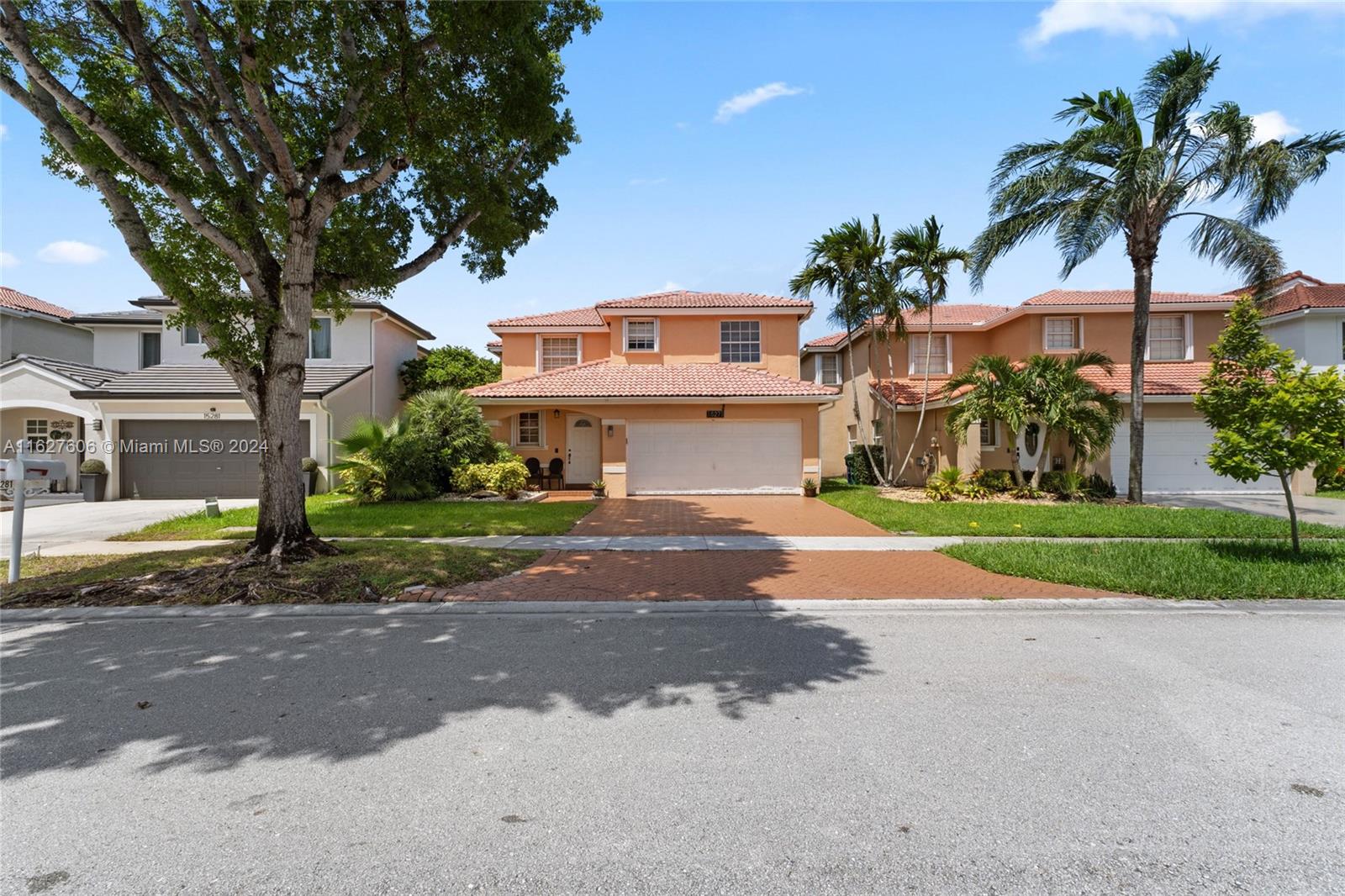 a view of a house with a yard and palm trees