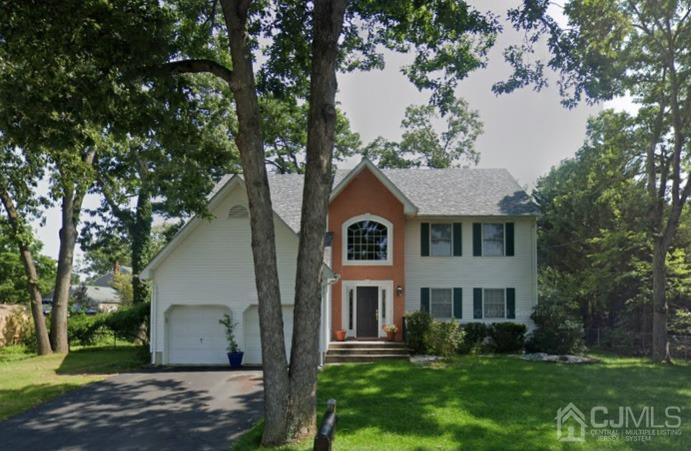 a front view of a house with a yard and trees