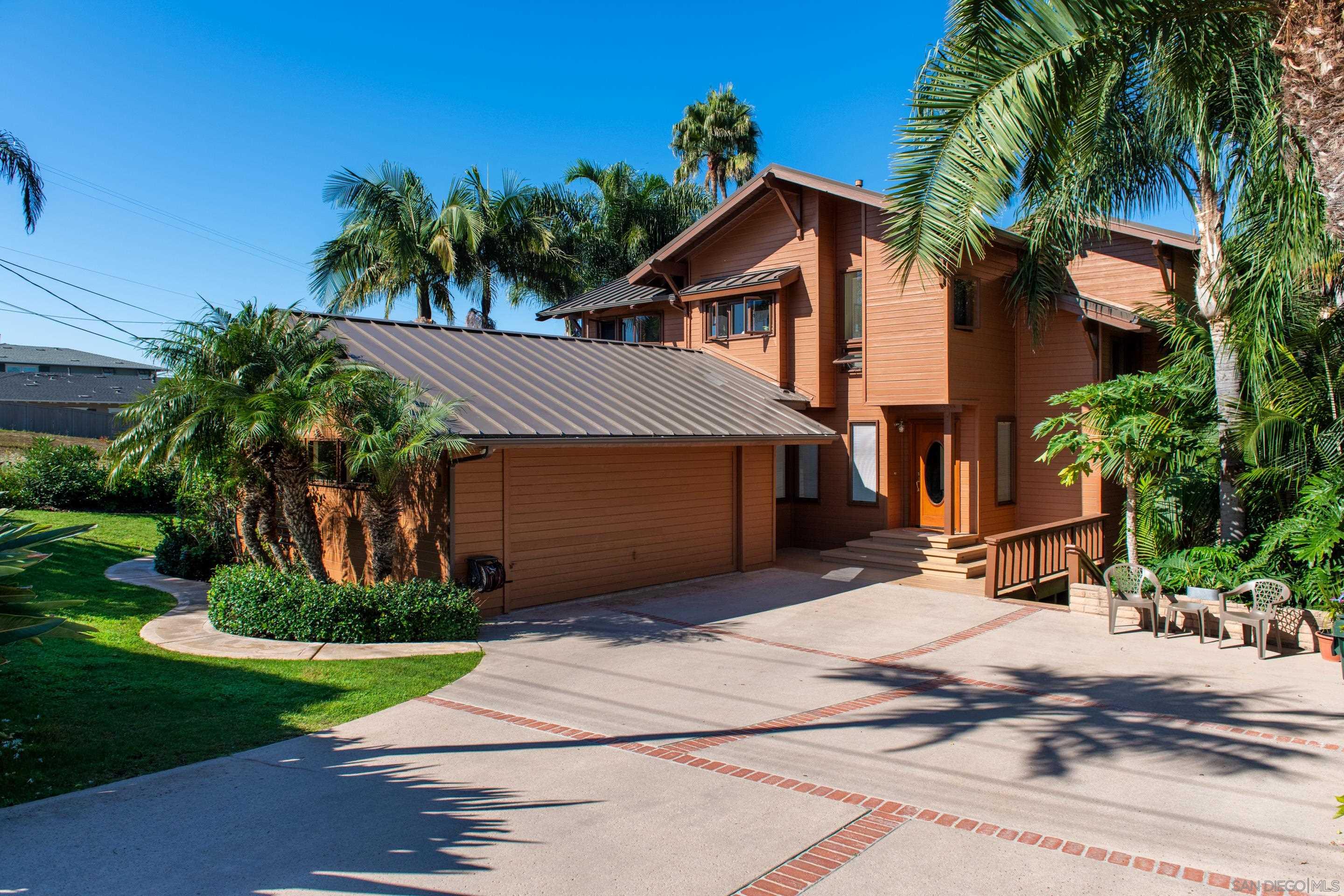 a front view of house with yard and trees around