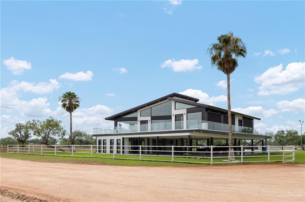 a front view of a house with a garden and lake view