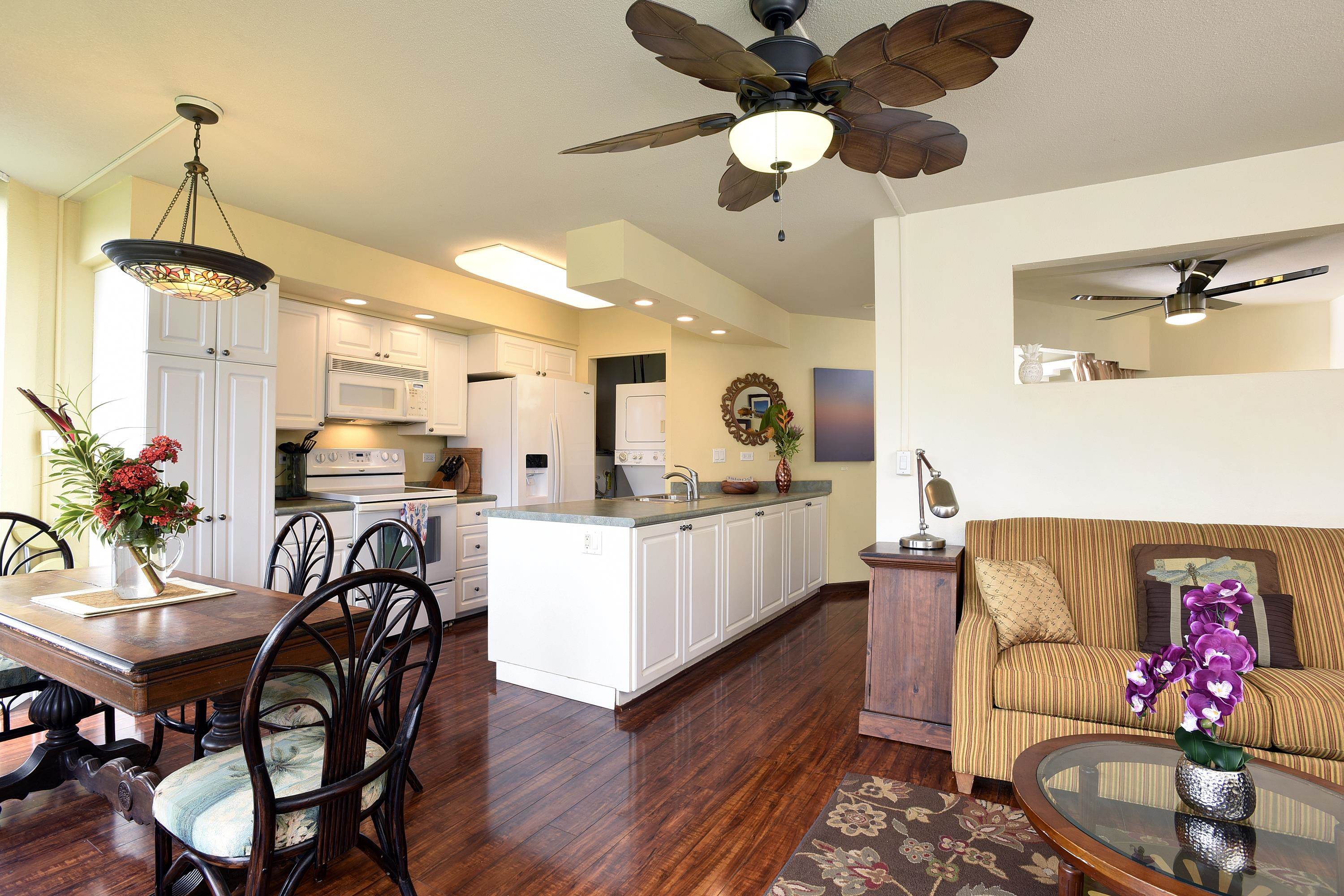 a living room with furniture kitchen view and a chandelier