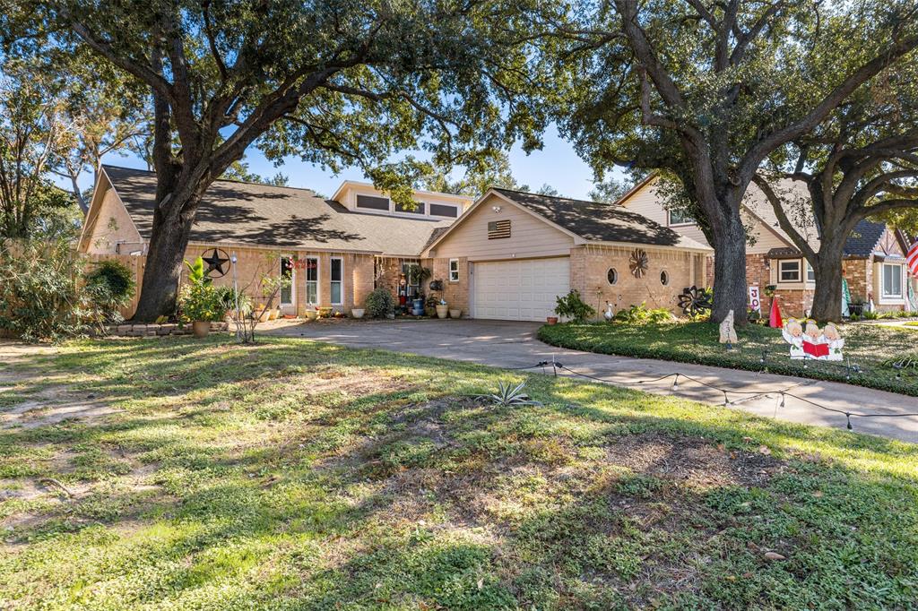 a view of a house with a yard and large trees