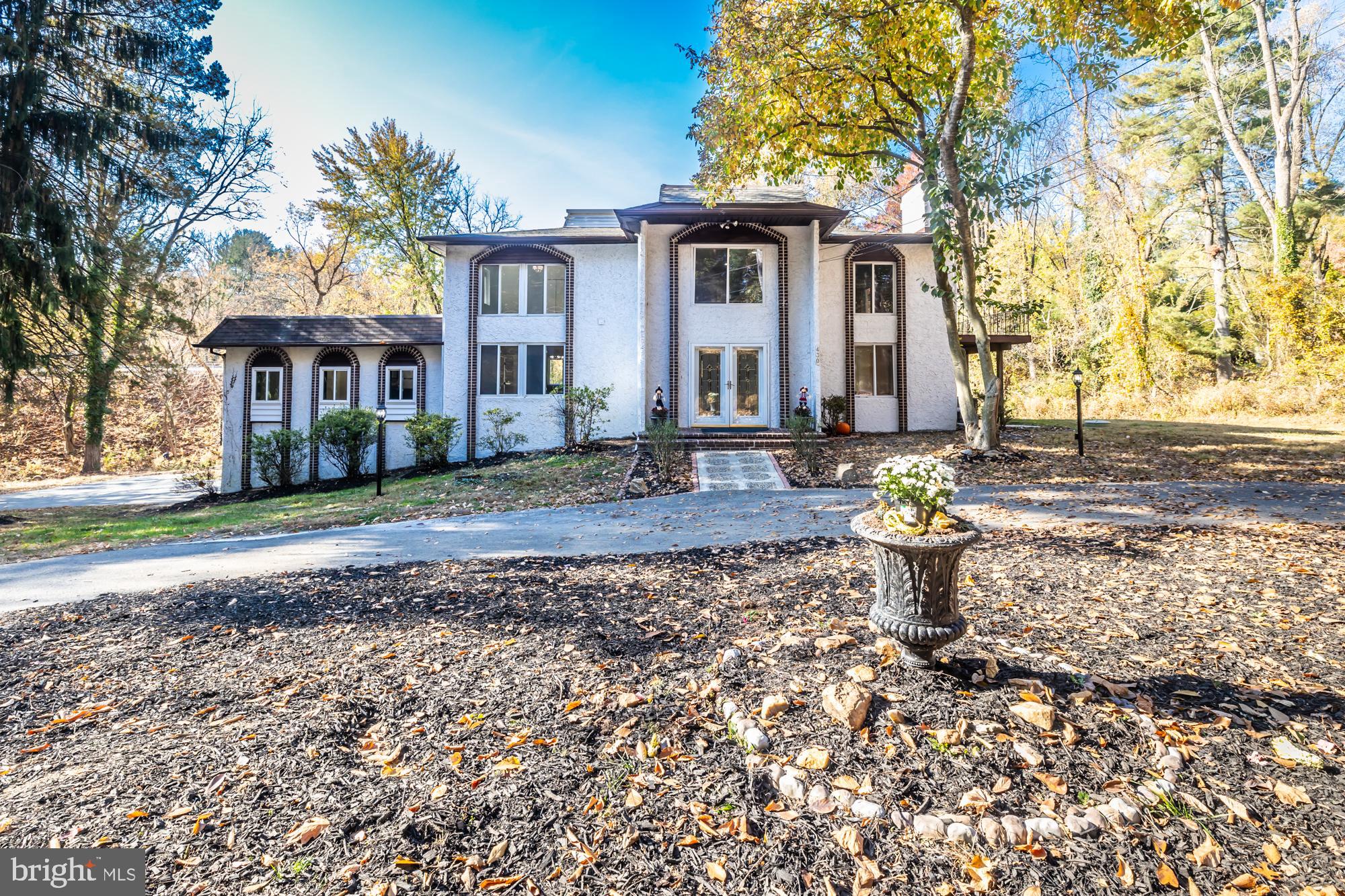 a front view of a house with a yard and trees