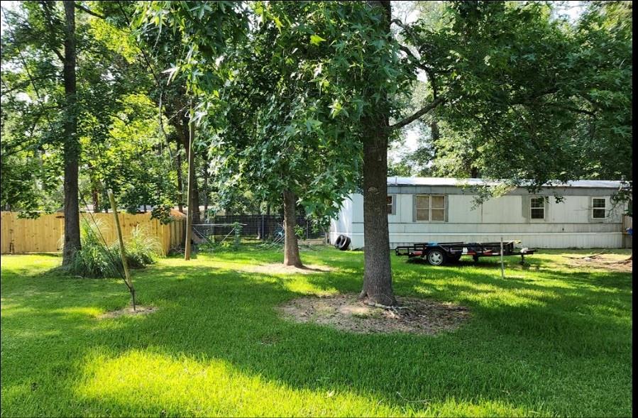 a view of a house with a big yard and a large tree