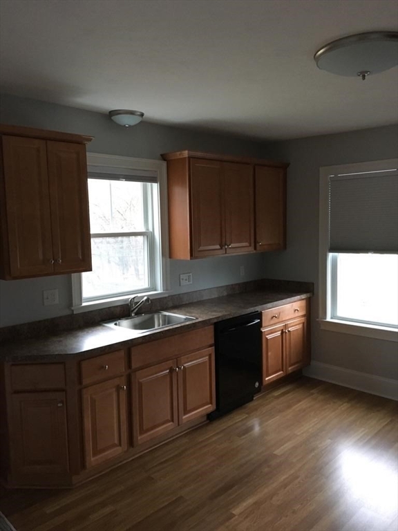 a kitchen with granite countertop a stove a sink and wooden cabinets