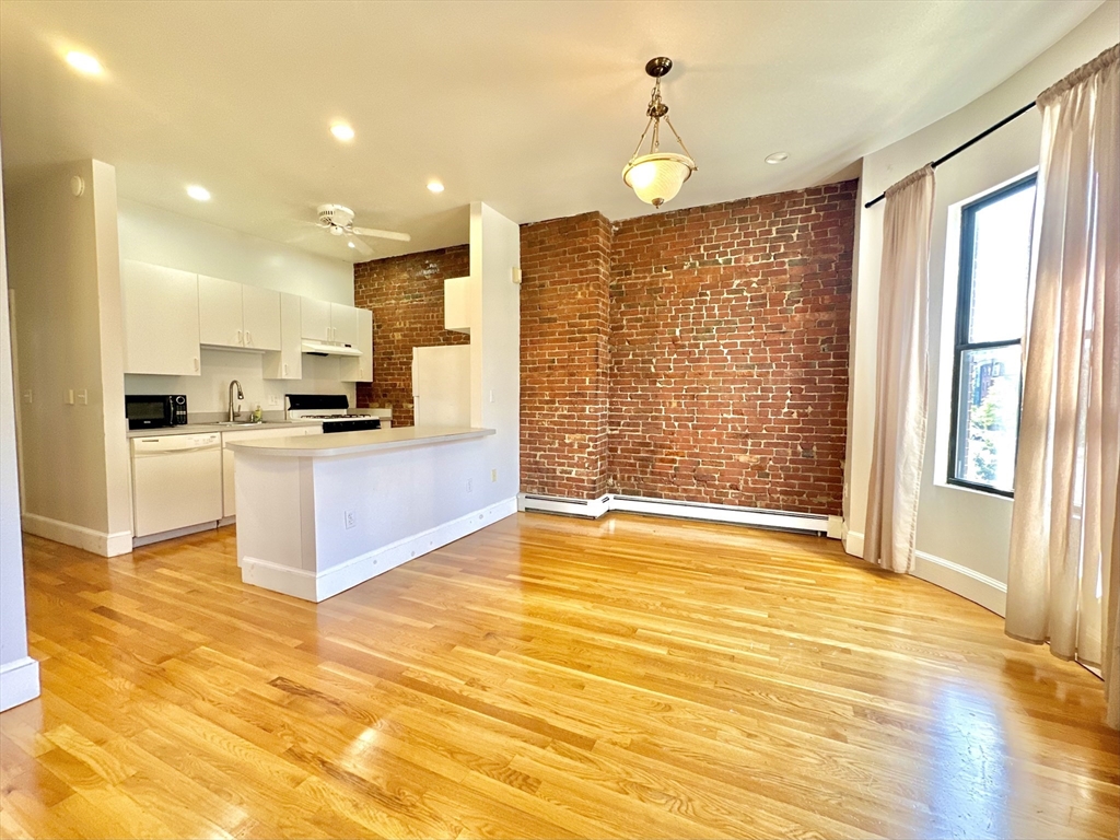 a large kitchen with cabinets and wooden floor