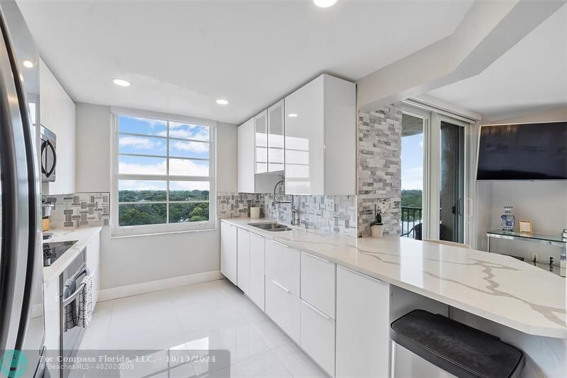 a bathroom with a double vanity sink a mirror and a bathtub next to a window