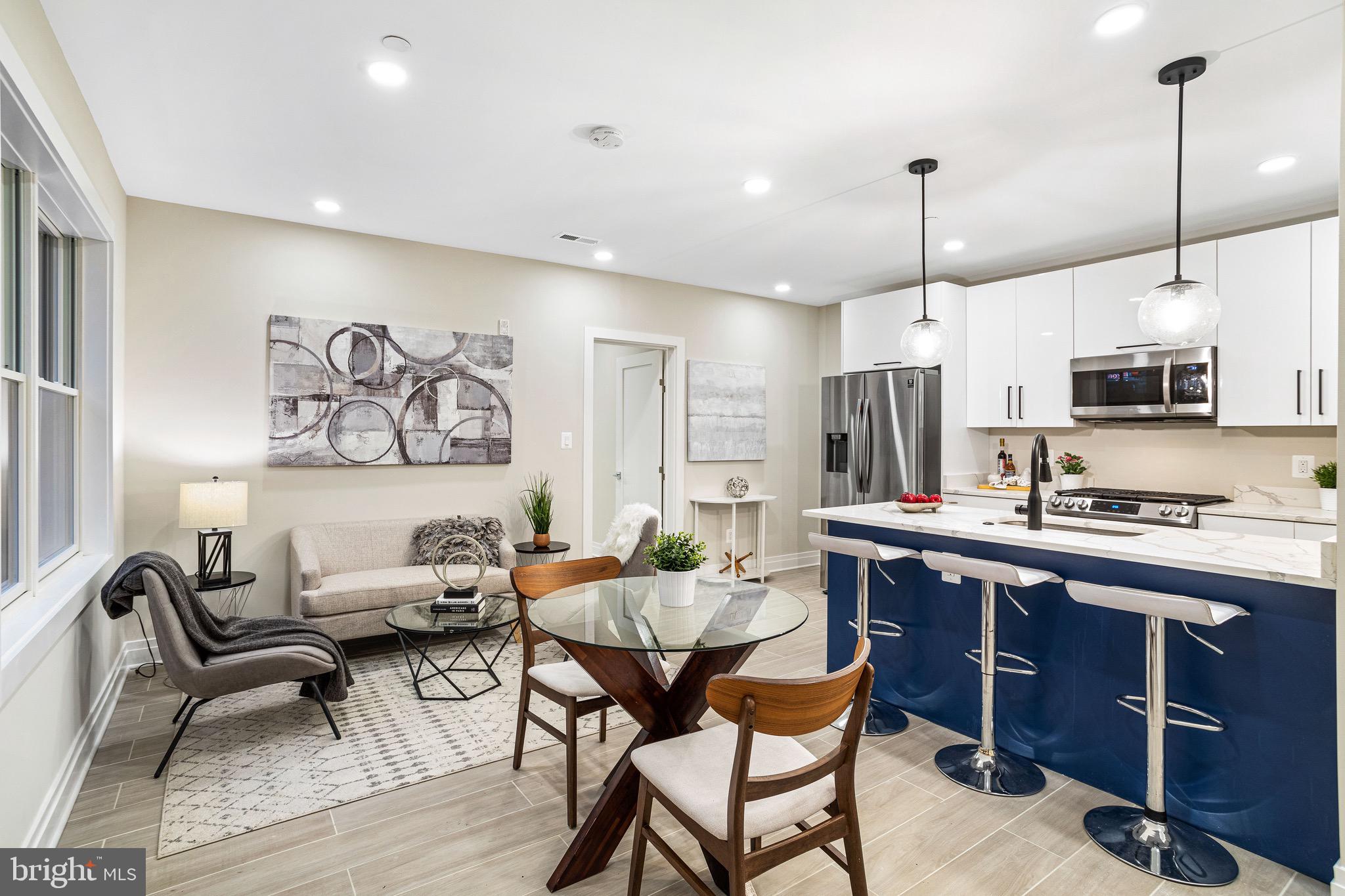 a kitchen with stainless steel appliances a dining table chairs stove and sink