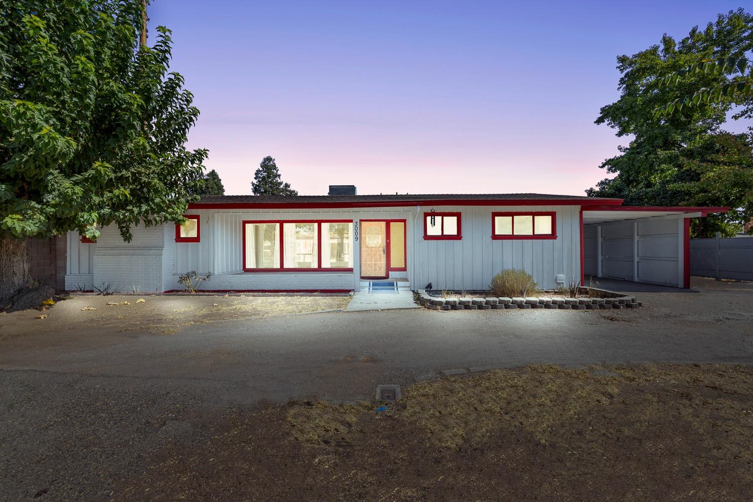 a view of a house with a yard and a wooden fence