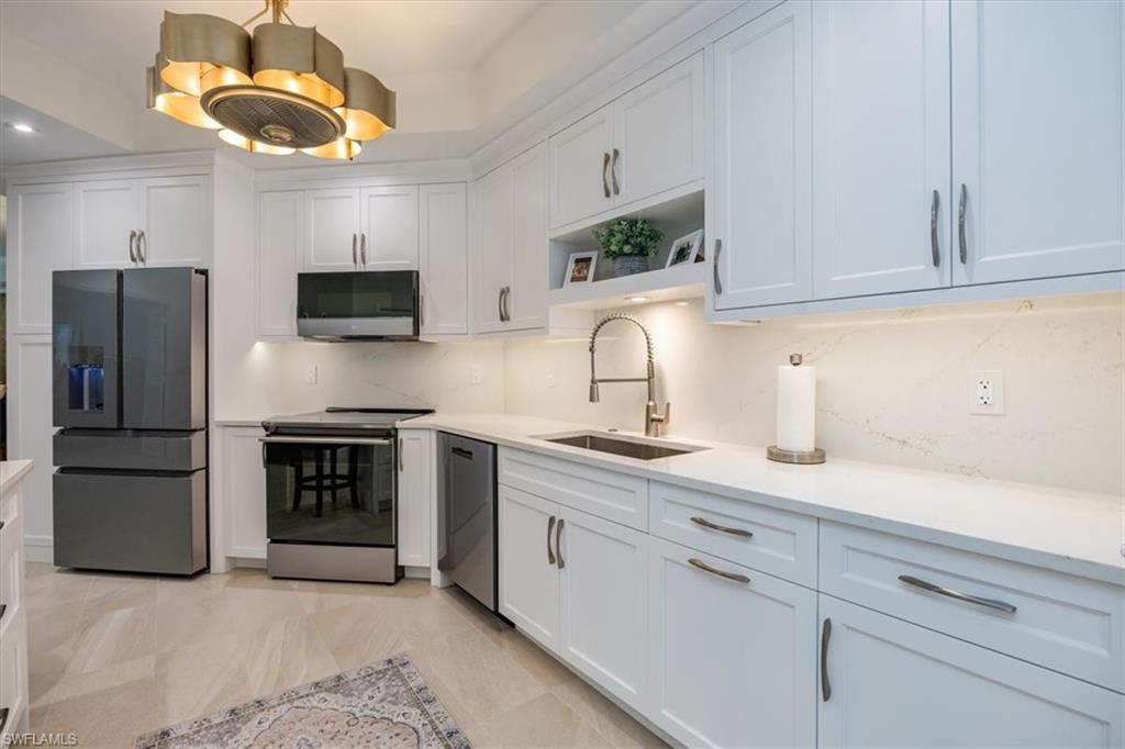 a kitchen with cabinets a window and stainless steel appliances