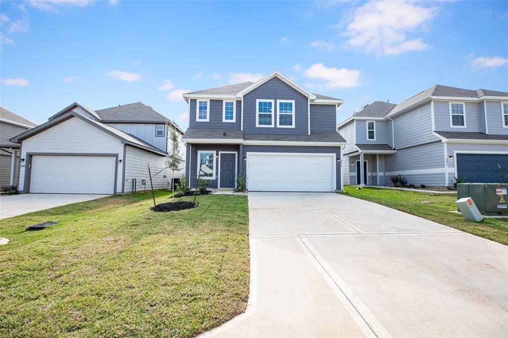 a front view of a house with a yard and garage