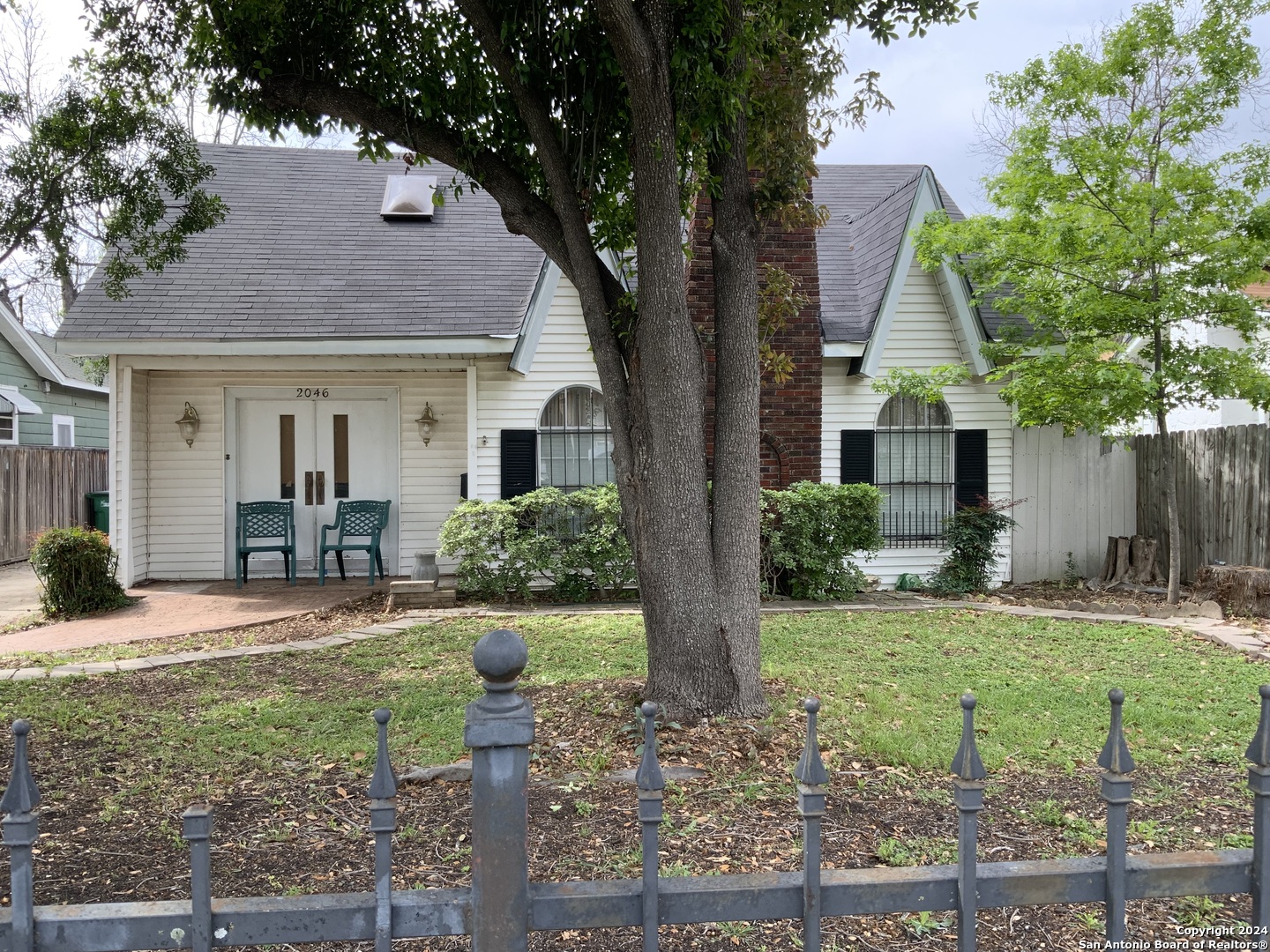 a front view of a house with a yard and potted plants