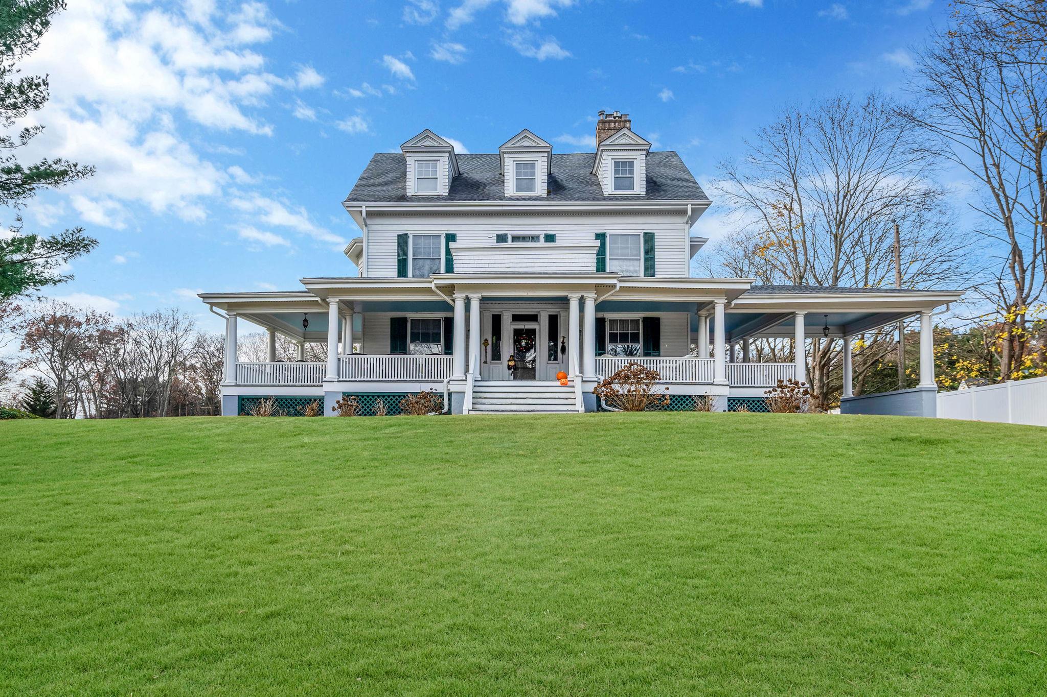 View of front facade featuring covered porch and a front lawn