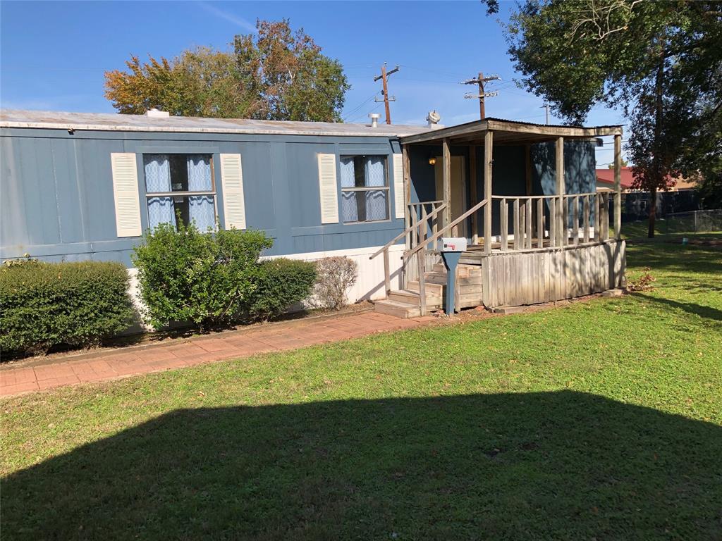 a view of a house with backyard and a tree