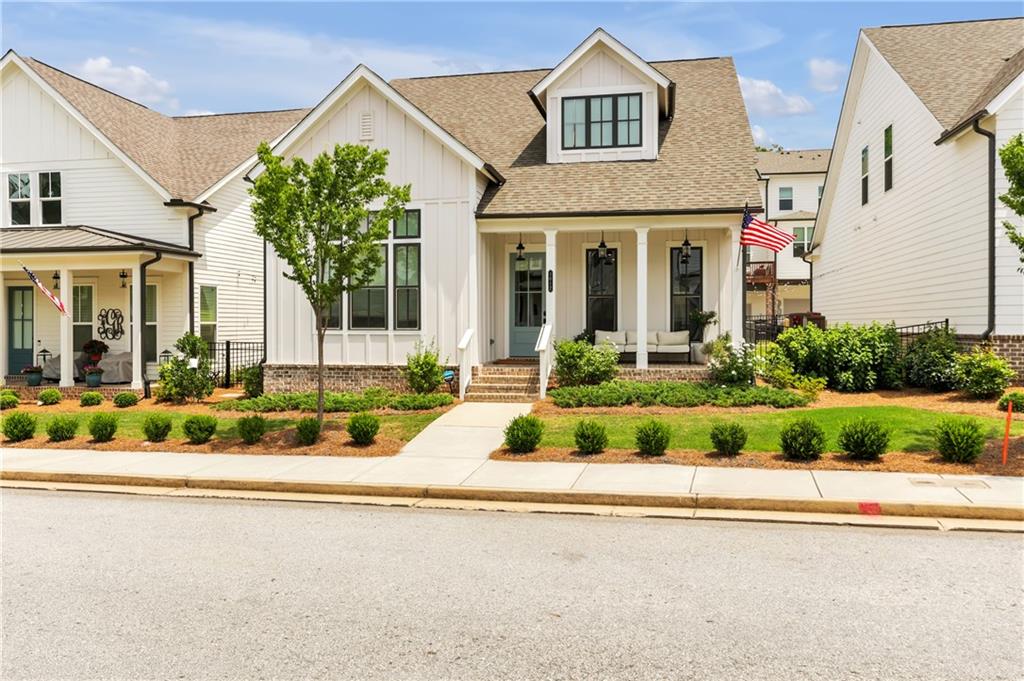 a front view of a house with a yard and potted plants