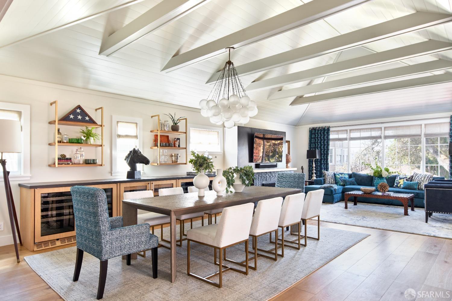 a dining room with wooden floor a chandelier a wooden table and chairs