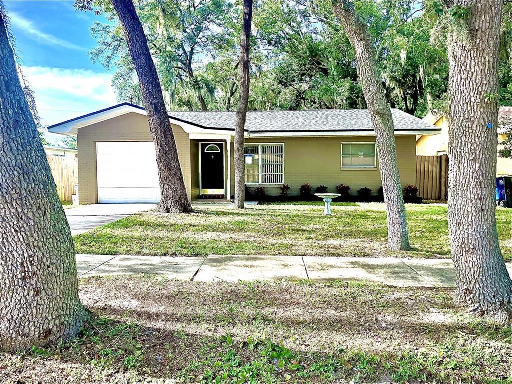 a view of a house with backyard and trees